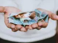 Hände halten zerknitterte Euro-Scheine. Das Geld ist für das geplante **auslandsjahr 3 monate** gedacht.