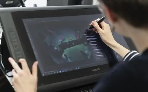 Person im Animation Studium nutzt Grafiktablett für digitale Kunst.