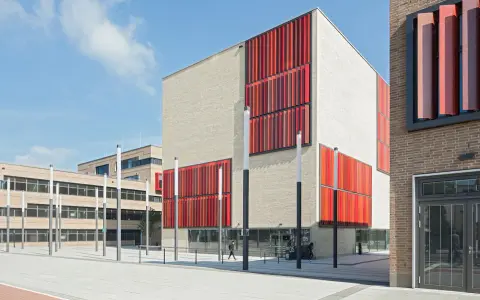 Moderne Gebäude der Hochschule Essen mit hellen Ziegelwänden und auffälligen roten Fassadenelementen.