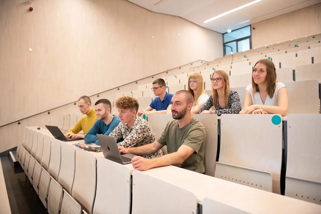 Studierende im Hörsaal, konzentriert auf ihre Laptops. Einblicke in das rehabilitationspsychologie studium.