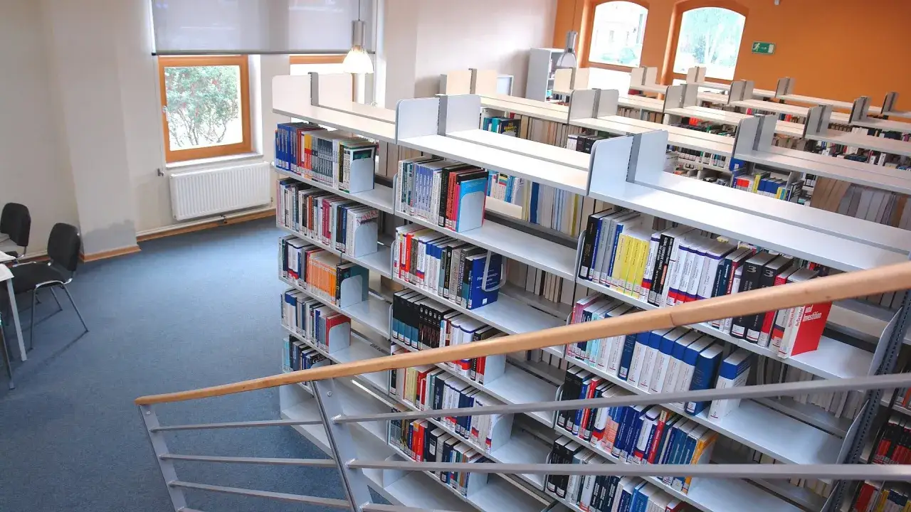 Regale voller juristischer Fachbücher in einer Bibliothek, ideal für das Jura Studium NRW.